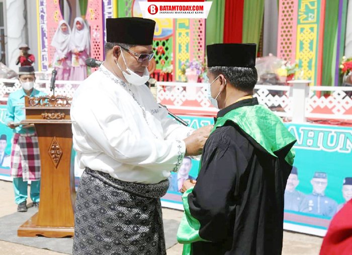 Bupati menyerahkan jubah secara simbolis kepada salah satu dewan hakim